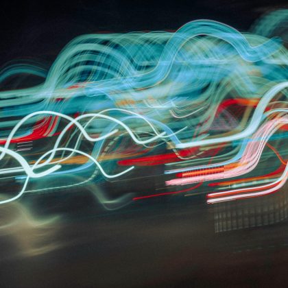Vibrant abstract photo of dynamic neon light trails in motion, creating a colorful visual effect.