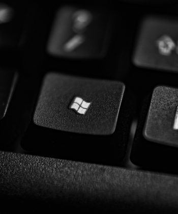 High-quality close-up of a Windows logo key on a black plastic keyboard.